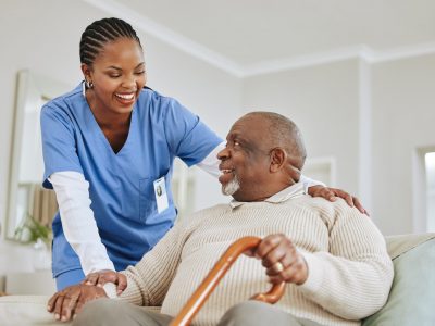 Caregiver, nurse or senior black man on a couch, retirement or help with healthcare or walking stick. Male person with a disability, patient or medical professional with support, recovery or healing.